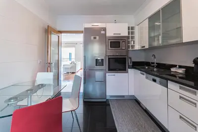 a kitchen with a glass table and stainless steel appliances at Costa Sol IX by Madeira Holiday Rentals in Funchal
