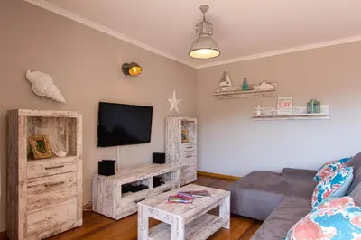a living room with a couch and a flat screen tv at Peace Haven in Calheta