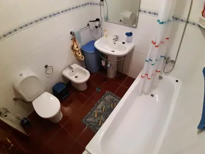 a bathroom with a tub and a toilet and a sink at Refugio das Matas in Porto Santo