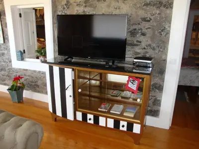 a television on a stand in a living room at Vila Vinha in Arco da Calheta