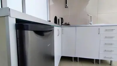 a kitchen with a sink and a stainless steel refrigerator at Colinas do Sol in Funchal