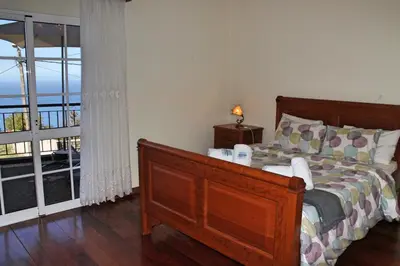 a bedroom with a bed and a sliding glass door at OurMadeira - Casa Vista Bela in Estreito da Calheta