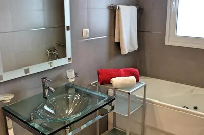 a bathroom with a glass sink and a bath tub at Tranquil villa with pool in Calheta ArcoView in Calheta