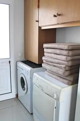 a laundry room with a washing machine and a stack of towels at Tranquil villa with pool in Calheta ArcoView in Calheta