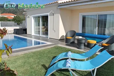 a backyard with a pool and a blue chair at Tranquil villa with pool in Calheta ArcoView in Calheta