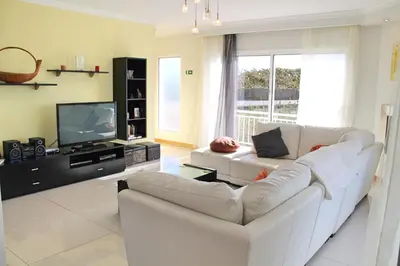 a living room with a white couch and a television at Tranquil villa with pool in Calheta ArcoView in Calheta
