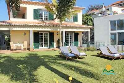 a yard with lounge chairs and a house at OurMadeira - Villa Luzia in Funchal