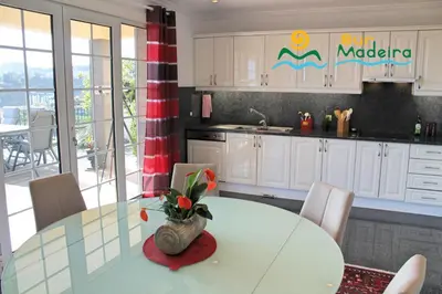 a kitchen with a table with a vase on it at OurMadeira - Villa Luzia in Funchal