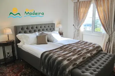 a bedroom with a large bed with a zebra blanket at OurMadeira - Villa Luzia in Funchal