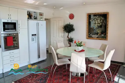 a kitchen with a table and chairs and a refrigerator at OurMadeira - Villa Luzia in Funchal
