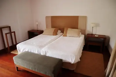 a bedroom with two beds and a ottoman at Casa D'Avo Beatriz in Gaula