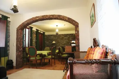 a living room with an archway and a table and chairs at Casa D'Avo Beatriz in Gaula