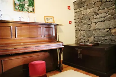 a piano in a room with a stone wall at Casa D'Avo Beatriz in Gaula
