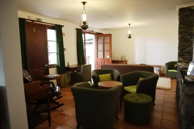 a living room with green chairs and a couch at Casa D'Avo Beatriz in Gaula