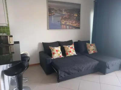 a living room with a blue couch with pillows at Vilas Horizonte in Porto Santo