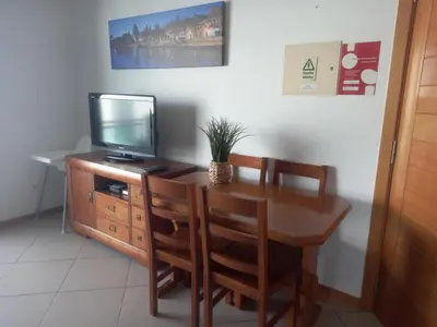 a dining room with a tv and a table and chairs at Vilas Horizonte in Porto Santo