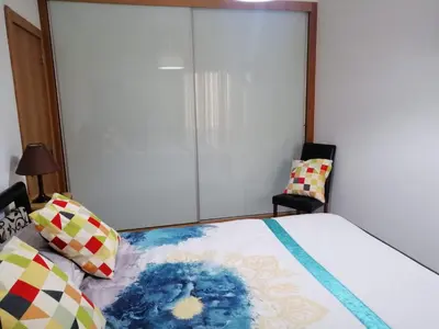 a bedroom with a bed and two chairs at Vilas Horizonte in Porto Santo