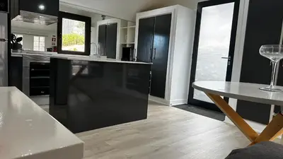 a kitchen with a black refrigerator and a table at Maison Blanche in Arco da Calheta