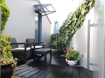 a patio with a table and some plants at Maison Blanche in Arco da Calheta