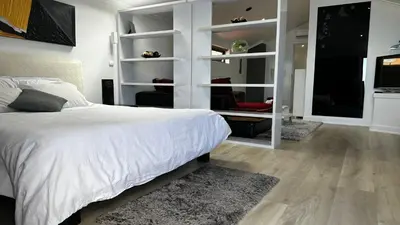a bedroom with a white bed and a tv at Maison Blanche in Arco da Calheta