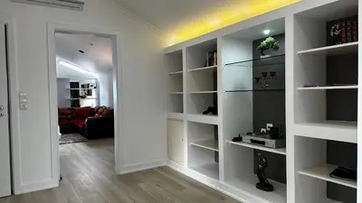 a room with white shelves and a living room at Maison Blanche in Arco da Calheta