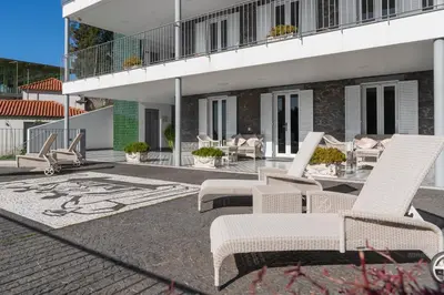 a patio with chairs and tables and a building at OurMadeira - Babosas Village in Funchal