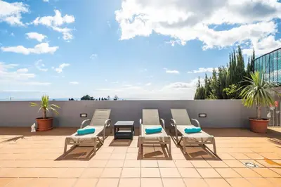 a white bedroom with a bed and a balcony at Funchal Bay View Villa by Homie in Funchal