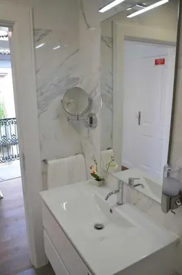 a white bathroom with a sink and a mirror at Edifício Charles 203 in Funchal