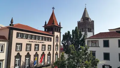 a building with a clock tower and a church at Edificio Charles 104 in Funchal