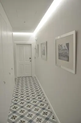 a hallway with a tile floor and a white door at Edificio Charles 104 in Funchal