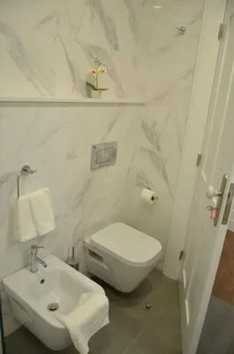 a white bathroom with a toilet and a sink at Edificio Charles 104 in Funchal