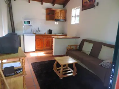 a living room with a couch and a kitchen at Quinta da quebrada in Santana