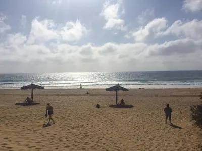 a group of people on a beach with umbrellas at Cantinho Solpraia in Porto Santo