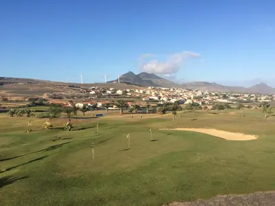 a golf course with a town in the background at Cantinho Solpraia in Porto Santo