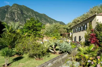 a garden with trees and a building and a mountain at Casa Da Piedade in São Vicente