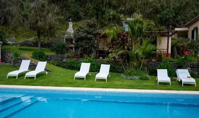 a group of lounge chairs next to a swimming pool at Casa Da Piedade in São Vicente