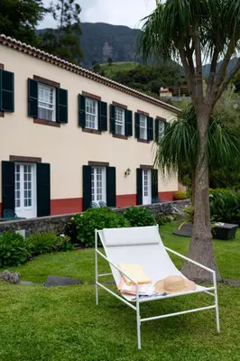 a chair in the grass in front of a building at Casa Da Piedade in São Vicente