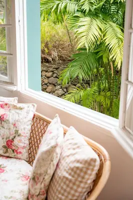 a basket with pillows sitting in front of a window at Casa Da Piedade in São Vicente
