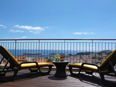 a patio with two chairs and a table on a balcony at Luxury Apartment Living Funchal in Funchal