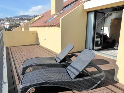 a pair of chairs on the balcony of a house at Luxury Apartment Living Funchal in Funchal