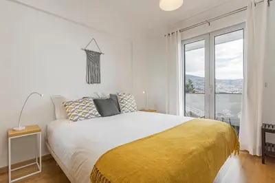 a bedroom with a large bed with a yellow blanket at Barreiros I by An Island Apart in Funchal