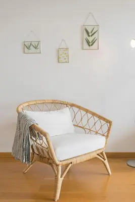 a wicker bench in a room with a white wall at Barreiros I by An Island Apart in Funchal