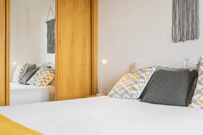 a bedroom with a bed and a mirror at Barreiros I by An Island Apart in Funchal