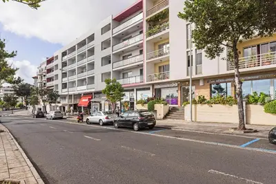 a street with cars parked in front of a building at Barreiros I by An Island Apart in Funchal