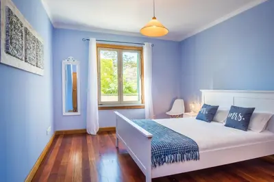 a blue bedroom with a bed and a window at The Cliff Side Apartment in Funchal