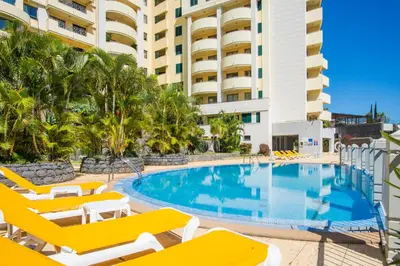 a swimming pool with lounge chairs and a resort at The Cliff Side Apartment in Funchal