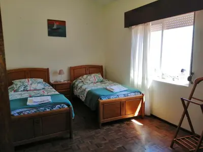 two beds in a small room with a window at Vista Boa in Porto da Cruz
