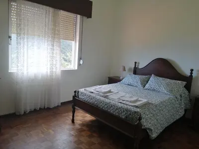 a bedroom with a bed and a window with curtains at Vista Boa in Porto da Cruz