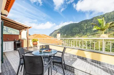 a patio with a table and chairs on a balcony at Cantinho das Feiteiras by Homie in São Vicente