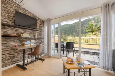 a living room with a table and chairs and a balcony at Cantinho das Feiteiras by Homie in São Vicente